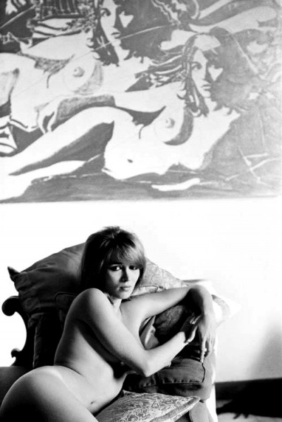 talitha_getty naked on a sofa with her own portrait as a background